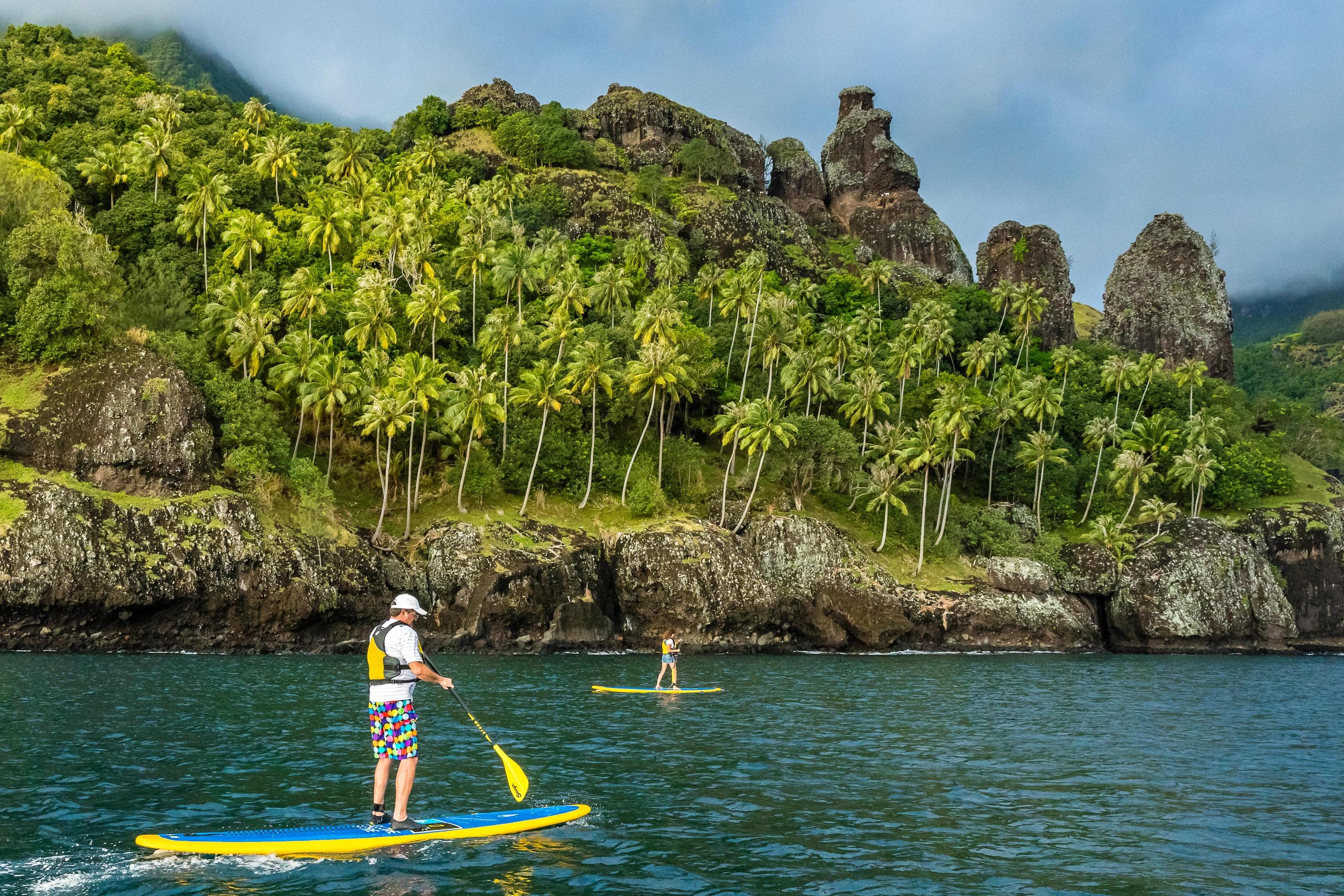 Two guests paddleboard in Futu Hiva, Marquesas Archipelago, French Polynesia